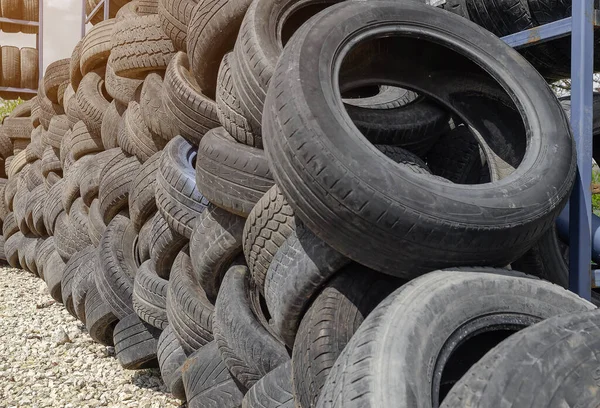 Car tires are stacked in large piles at car repair shop