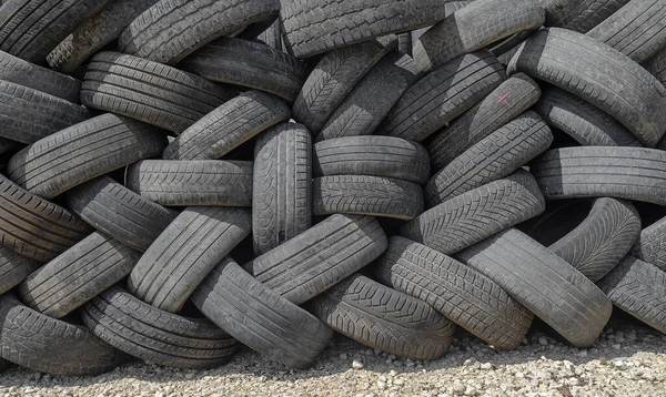 Car tires are stacked in large piles at car repair shop