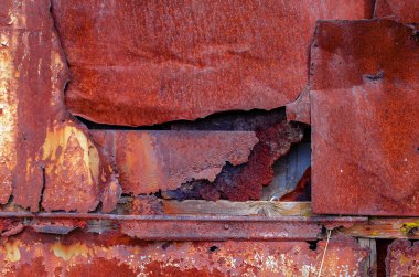 Paslı metal kaplamalı bir delik.