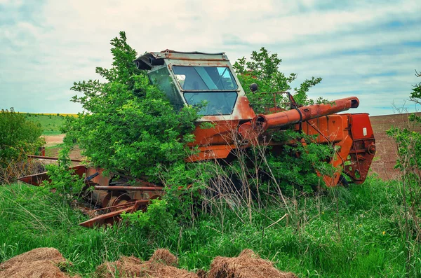 古い放棄された錆びたコンバインフィールド上の茂み — ストック写真