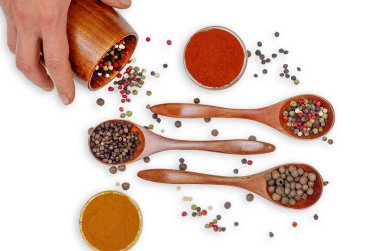 Kadın eli ahşap bardaktan siyah biberi beyaz masaya baharat kompozisyonu olarak döker. Yemek ve yemek. Sağlıklı beslenme ve organik ürünler. Mutfak havası..