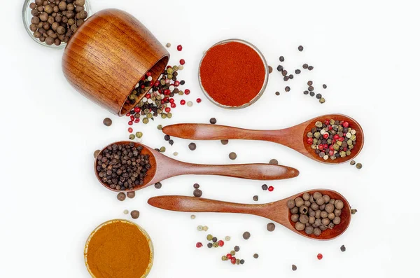 Şeffaf küçük kaselerde çeşitli aromatik baharatlar ve baharatlar ve beyaz arka planda ahşap kaşıklar. Web sitesi, yemek ekran koruyucuları için kullan.