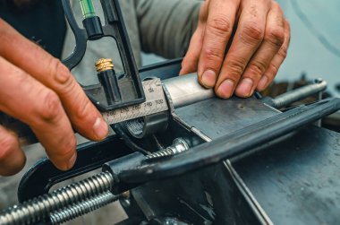 Ana ölçü, metal borunun uzunluğunu klemple ölçer. Metal ürünü kaynak için hazırlıyorum. Endüstriyel kavram.