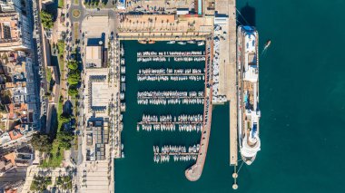 İspanya, Cartagena limanının havadan görüntüsü. Büyük bir yolcu gemisi ve turkuaz suyun arka planında demirli küçük tekneler. Seyahat ve tatil kavramı.