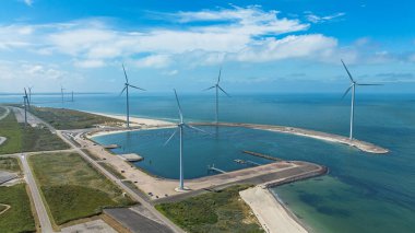 Bulutlu gökyüzünün altındaki yel değirmenlerinin drone görüntüsü. Hollanda 'da. Sürdürülebilir kalkınma, yenilenebilir enerji, elektrik üretiminde yeni teknolojiler. Rüzgar santrali.