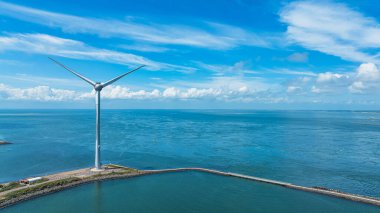 Bulutlu gökyüzünün altındaki yel değirmeninin insansız hava görüntüsü. Hollanda 'da. Sürdürülebilir kalkınma, yenilenebilir enerji, elektrik üretimindeki yeni teknolojiler.