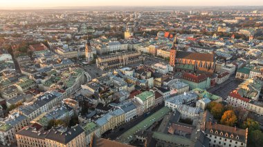 St. Mary Bazilikası ve güneşli sabah ışığında tarihi Avrupa mimarisi ile Krakow Eski Şehir Meydanı manzarası. Turizm ve seyahat.