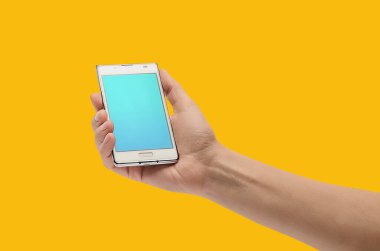 Eski cep telefonunu tutan bir kadının yakın çekimi. Sarı arka plan, izole edilmiş. İnsanlar, teknoloji, iş, meslek ve yaş. Telefon konseptiyle iş. Boşluğu kopyala.