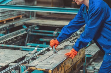 Endüstriyel makineler üzerinde hassas ayarlamalar yapan kadın işçi. Profesyonellik kavramı, detaylara dikkat ve modern imalata kadın katılımı.