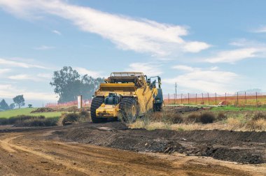 Ekonomik büyümeyi, yollardaki yatırımı ve ulaşım ağlarının uzun vadeli gelişimini simgeleyen büyük altyapı projesinde çalışan ağır inşaat araçları.