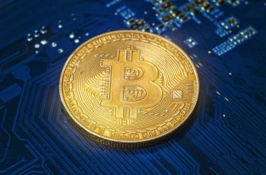 Mavi bilgisayar devre kartına yerleştirilmiş altın Bitcoin para. Yakın çekim görüntüsü kripto para birimini, engelleme teknolojisini ve dijital finansal sistemleri sembolize ediyor. Merkezi olmayan ekonomi kavramı, çevrimiçi yatırım, fintech yeniliği ve modern sanal curre