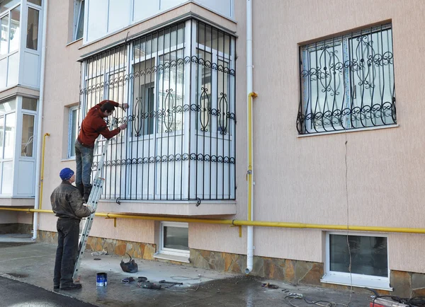 KIEV, UCRANIA - FEBRERO, 5, 2016: Los contratistas instalan barras de seguridad de hierro de ventana — Foto de Stock