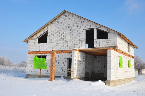 Nuova costruzione di casa da blocchi di cemento armato autoclavato. Inverno cantiere casa . — Foto Stock