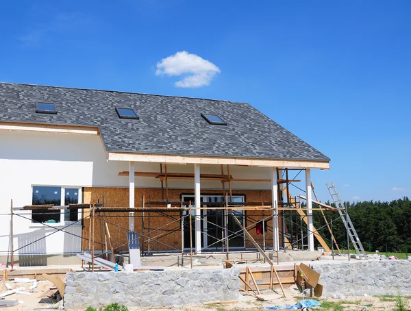 Construção e renovação da casa rural com clarabóias, beirados, janelas, fachada de fixação, isolamento, gesso e pintura casa fachada parede. Instale soffits e beirados de plástico Exterior . — Fotografia de Stock