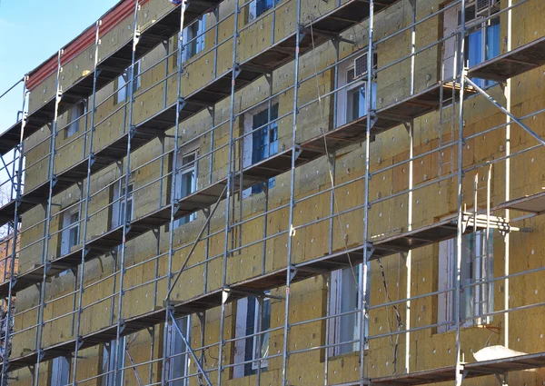 Renovación de la pared de la casa de eficiencia energética para ahorrar energía. Aislamiento térmico exterior de la pared de la casa con lana mineral, hospital de construcción en construcción . — Foto de Stock