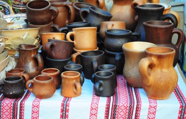 Geleneksel seramik sürahi ve bardak dekoratif havlu üzerinde. El yapımı Ukrayna seramik seramik seramik kaplar ve kupa ile yol kenarına yerleştirilen bir pazarda, vitrin açık havada.