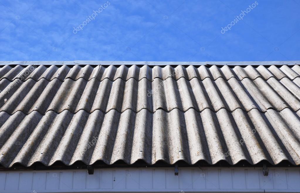 Asbestos Roof. Dangerous asbestos roof tiles on house roof. — Stock