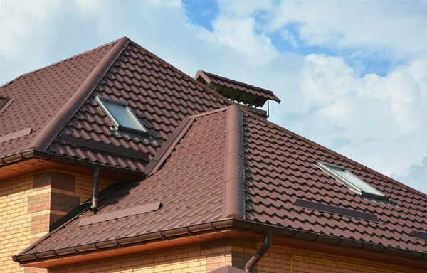 New roofing construction with attic skylights, rain gutter system, roof windows and roof protection from snow board, snow guard exterior. — Stock Photo, Image