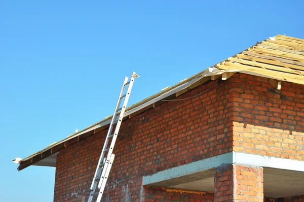 Construcción de techos. Estructura de techo de madera Construcción de casa sin terminar con escalera de metal . — Foto de Stock