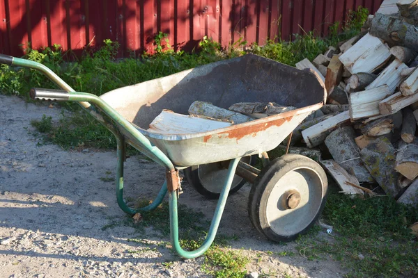 Garden wheelbarrow with firewood — Stock Photo, Image