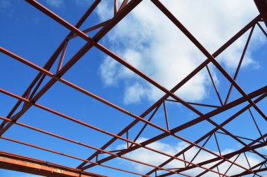 Çelik çatı bulutlar gökyüzü arka plan detaylarla makasları. Çelik çatı makasları beton direk görünümünden oturan ev fabrika kopya alanı ile içinde.