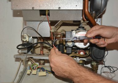 KYIV, UKRAINE - 07 Ekim 2020: Gaz kazanının bakımı: Bir gaz kasası mühendisi güvenli ve verimli çalışması için yıllık bir kazan hizmeti sunuyor..