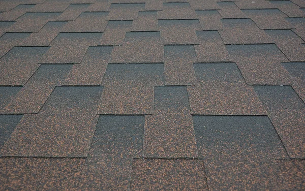 Asphalt shingles textured background. A close-up on copper brown dimensional, or architectural roofing asphalt shingles background.