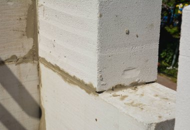 Otoklavize edilmiş beton bloklardan (AAC) yapılmış duvar duvarının bir pencere alanı için testereli beton tuğla ile yakın plan bir köşesi.. 