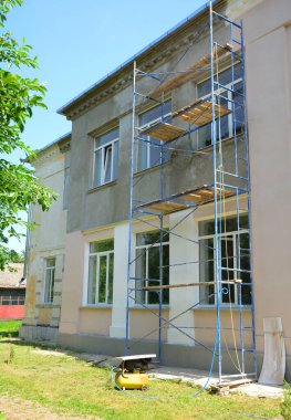 Evin tadilatı sırasında bir binanın dış duvarını sıva, işleme, kaymak ve boyama..