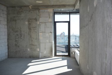 Yeni inşa edilmiş boş bir apartmanın içeriden görünüşü, onarımı olmayan bir daire, yeni inşa edilmiş, inşa edilmiş bir apartmanın penceresi var.. 