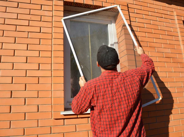 Mężczyzna Instaluje Moskitierę Siatkę Ekran Owadów Panelowych Oknie Zewnątrz Aby — Zdjęcie stockowe