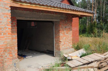 Garaj kapısı kurulumu: yeni inşa edilmiş tuğladan bir garajın garaj kapısına kapı panelleri takmak. 