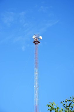 5G, beşinci nesil teknoloji: Mavi gökyüzünde cep telefonu ve interneti radyo dalgalarıyla birbirine bağlayan yerel bir anten veya anten.