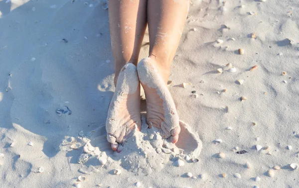 在海滨休息 在阳光下躺在沙滩上 脚底被沙子覆盖在海上的女人的腿的特写 — 图库照片