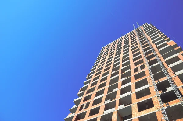 Trabajos de construcción de obra contra el cielo azul. Copie el espacio para agregar sus propias listas, notas, texto, dibujos . — Foto de Stock