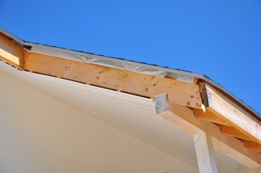 Saçak, ahşap kirişler ile ev köşesinde. Soffits agains mavi gökyüzü yüklemek