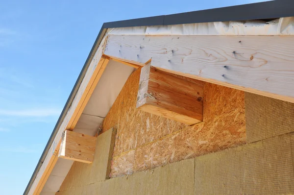 New house wall facade insulation against blue sky. Roof insulation detail.