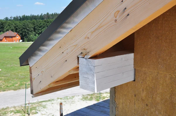 Installare morbidezza e dettaglio isolamento del tetto. Angolo di casa con gronda, travi, capriate . — Foto Stock