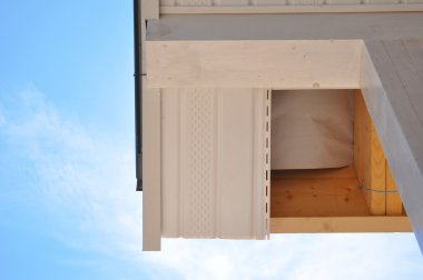 Saçak yaz arka plan ile ev köşesinde. Soffits yükleyin. Çatı kaplama işleri.