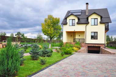 Tepe, güneş enerjili su ısıtma paneli, döşenmiş çatı, yağmur oluk, çit, garaj çatı penceresi, kar baca, çatı koruma ile modern ev güzel bahçe peyzaj