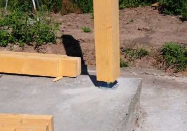 Vida ile Beton inşaat alanında ahşap sütun. Ahşap sütunlar Vakıflar veya platformlar üzerinde yerleştirilmiş yapılardır.