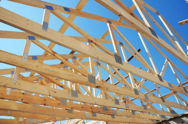 Nueva casa de construcción residencial enmarcando contra un cielo azul. Construcción de techos. —  Fotos de Stock