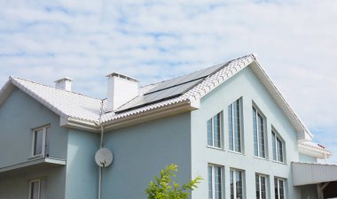 Güneş panelleri ve Mavi Gök 'ün Altında Beyaz Döşemeli Çatı ile Modern Enerji Verimli Ev