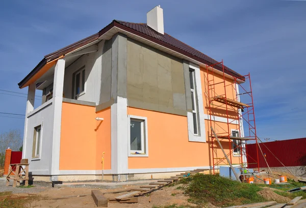 Construction or repair of the rural house with balcon, eaves, windows, chimney, roofing, fixing facade, insulation, plastering and using color. House construction.