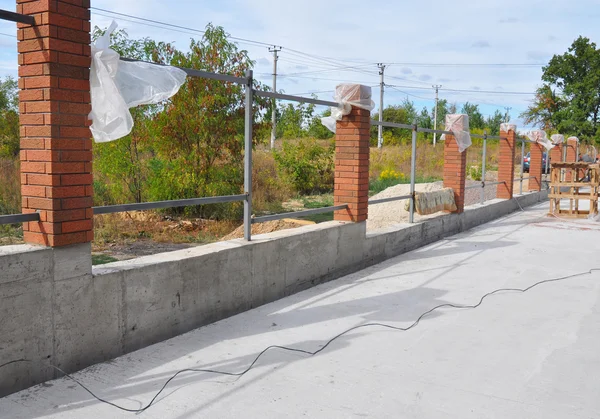 Bir Metal ve beton, demir çubuk Framework ile tuğla çit bina — Stok fotoğraf