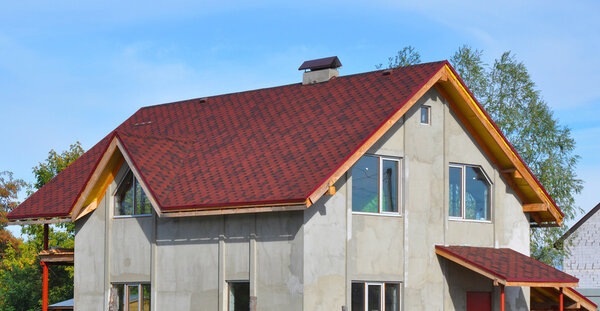 New House Roof Covered with Bitumin Tiles. Asphalt Shingles Roof