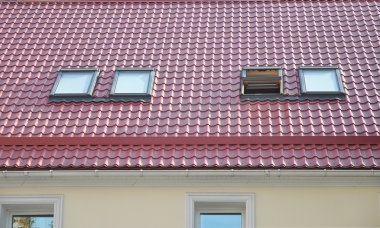 Red Metal Tiled Roof with New Dormers, Roof Windows, Skylights, Rain Gutter System and Roof Protection from Snow Board clipart