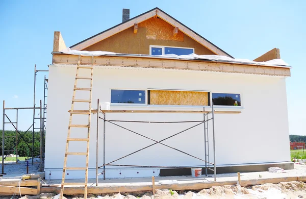 Construction or repair of the rural house with insulation, eaves, windows, wall insulation,chimney, roofing, fixing facade, plastering and using color. — Stock Image Construction or repair of the rural house with insulation, eaves, windows, wall insulation,chimney, roofing, fixing facade, plastering and using color. Stock Image