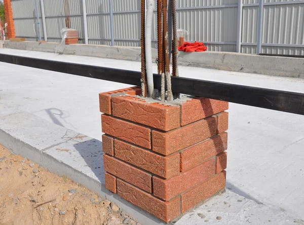 Closeup on Building New Fence Column with Bricklaying,  Light Wires and Iron Bar. Whether you are laying brick to build a mailbox enclosure, or building a brick house, the process is the same. — стокове фото
