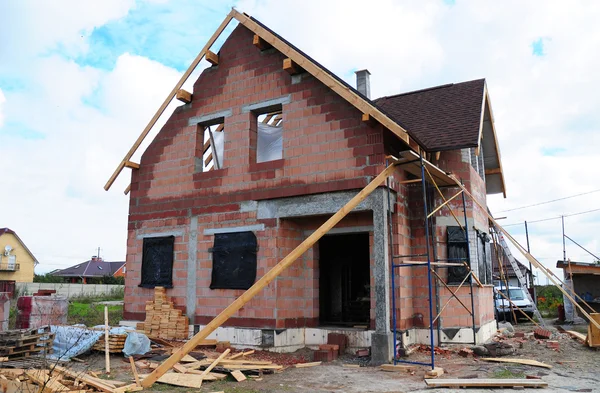 Roofing Construction and Building New  Ceramic Bricks House with Modular Chimney, Skylights, Attic, Facade and Eaves Exterior. Install, Repair Asphalt Shingles on the Rooftop Outdoor.